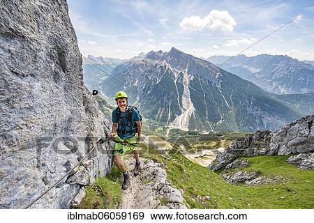 Stock Photo - Mountaineer on a secured via ferrata, Mittenwalder Höhenweg, view of mountain panorama, Karwendel Mountains, Mittenwald, Bavaria, Germany, Europe. Fotosearch