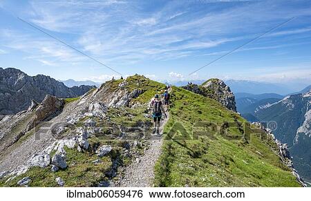 Stock Photograph - Mountaineers hiking on a ridge, fixed rope route Mittenwalder Höhenweg, Karwendel Mountains, Mittenwald, Bavaria, Germany, Europe. Fotosearch