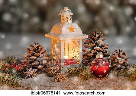 Stock Image - Natural Christmas decoration with burning lantern during snowfall. Fotosearch