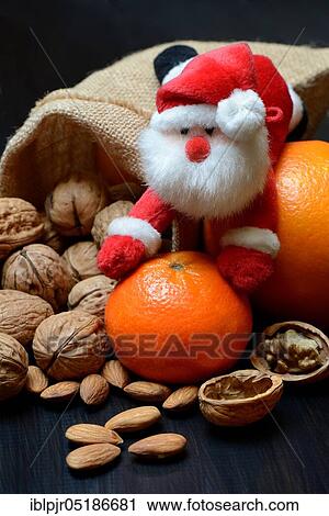 Stock Image - Nuts and fruits for St. Nicholas Day, almonds, apples, pears, orange, mandarin. Fotosearch