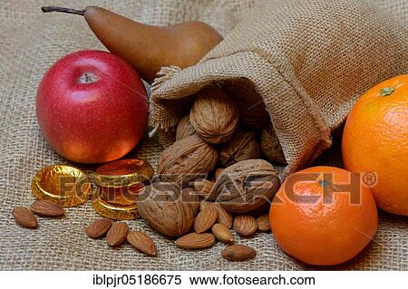 Nuts and fruits for St. Nicholas Day, almonds, apples, pears, orange, tangerine, gold coins, chocolate coins View Large Photo Image Stock Photography - Nuts and fruits for St. Nicholas Day, almonds, apples, pears, orange, tangerine, gold coins, chocolate coins. Fotosearch
