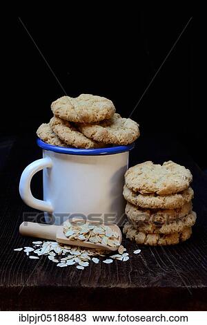 Stock Image - Oatmeal biscuits in cup and oatmeal, oatmeal cookies, oatmeal biscuits, oatmeal biscuits, oatmeal cookies. Fotosearch