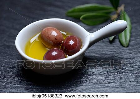 Stock Image - Olive oil and olives in bowls, Amphisis olives, Greek olives from Amphissa, Greece, Europe. Fotosearch