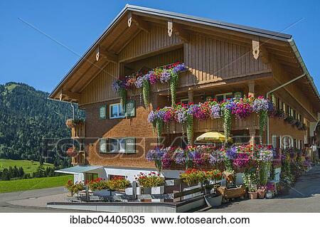Outside of home with wooden shingle facade, extensively decorated with flowers, Balderschwang, Oberallgäu, Bavaria, Germany, Europe View Large Photo Image Stock Photography - Outside of home with wooden shingle facade, extensively decorated with flowers, Balderschwang, Oberallgäu, Bavaria, Germany, Europe. Fotosearch