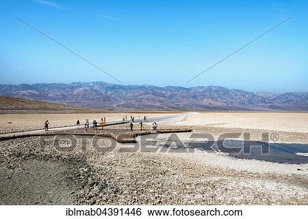 Stock Photograph - People on a jetty at Badwater Basin, the lowest point in North America, with Panamint Range, Black Mountains, Death Valley, Mojave Desert, California, USA, North America. Fotosearch