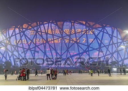 Stock Image - People on square in front of illuminated National Stadium in the Olympic Park, dusk, Beijing, China, Asia. Fotosearch