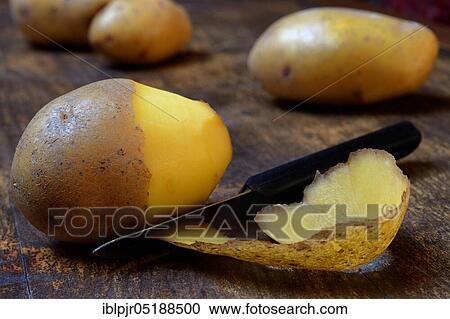 Stock Image - Potato peeling with peeler, Solanum tuberosum, potato peel, potato peel. Fotosearch