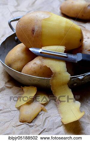 Stock Image - Potato peeling with peeler, Solanum tuberosum, potato peel, potato peel. Fotosearch