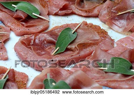 Stock Image - Preparation of Saltimbocca alla romana, Prepared escalopes with ham and sage leaves, Veal escalope, sage, sage leaf, sage leaves, Parma ham, Preparation, Veal escalope, Italy, Europe. Fotosearch