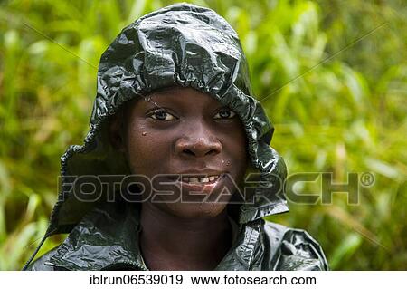 Stock Photo - Pretty girl wearing a raincape smiling, Sao Tome, Sao Tome and Principe, Atlantic ocean, Africa. Fotosearch