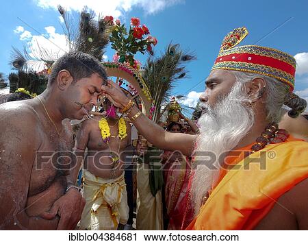 Stock Image - Priest blessing Kavadi dancer with pierced cheek, Sri Kamadchi Ampal Temple festival, Hindu temple festival, Hamm, Ruhr district, North Rhine-Westphalia, Germany, Europe. Fotosearch