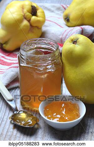 Stock Image - Quince jelly in glass with spoon, quince, Cydonia oblonga. Fotosearch