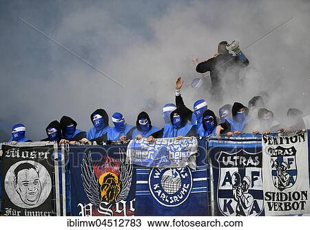 Stock Image - Radical fans at soccer match, hooded hooligans with Bengal light, pyrotechnics, fan section KSC Karlsruher SC, Merdedes-Benz-Arena, Stuttgart, Baden-Württemberg, Deutschland. Fotosearch