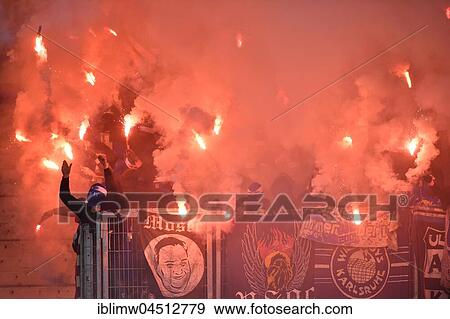 Stock Photo - Radical fans at soccer match, hooded hooligans with Bengal light, pyrotechnics, fan section KSC Karlsruher SC, Merdedes-Benz-Arena, Stuttgart, Baden-Württemberg, Deutschland. Fotosearch