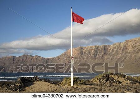 Red flag flying warning of bathing danger, La Caleta de Famara, Lanzarote, Canary islands, Spain, Europe View Large Photo Image Stock Image - Red flag flying warning of bathing danger, La Caleta de Famara, Lanzarote, Canary islands, Spain, Europe. Fotosearch