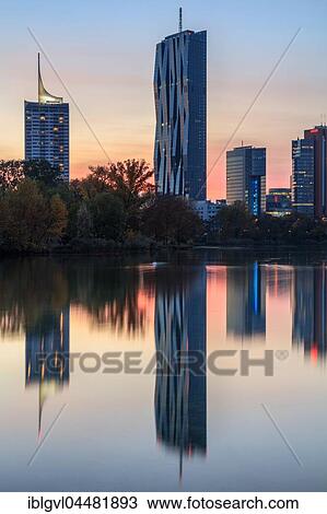 Stock Image - Reflection, skyscrapers, Donau City on the Old Danube, Kaiserwasser, dusk, Vienna, Austria, Europe. Fotosearch