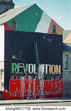 Stock Photo - Revolution lettering on a house front is being repaired, Falls Road district, historical photograph, 08. 09. 1986, Belfast, Northern Ireland. Fotosearch