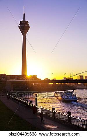 Rheinturm with Rhine and cargo ship at sunset, Düsseldorf, North Rhine-Westphalia, Germany, Europe View Large Photo Image Stock Photo - Rheinturm with Rhine and cargo ship at sunset, Düsseldorf, North Rhine-Westphalia, Germany, Europe. Fotosearch