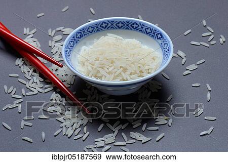 Stock Photo - Rice grains in husk and chopsticks, basmati rice, Oryza sativa, uncooked. Fotosearch