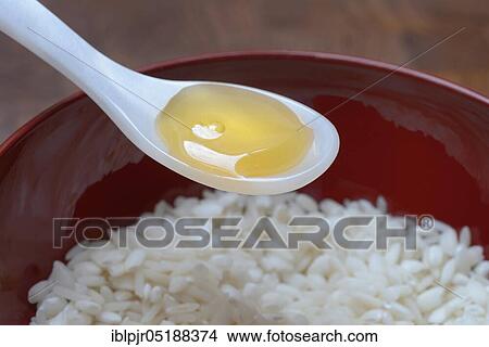 Picture - Rice syrup, rice syrup in spoon, rice in bowl, rice honey. Fotosearch