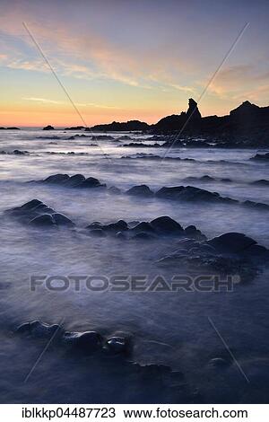 Stock Image - Rocks in the sea, rocky coast in the evening light, Atlantic Coast, Hartland Quay, Devon, United Kingdom, Europe. Fotosearch