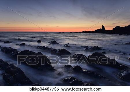 Stock Photography - Rocks in the sea, rocky coast in the evening light, Sunset, Atlantic Coast, Hartland Quay, Devon, United Kingdom, Europe. Fotosearch