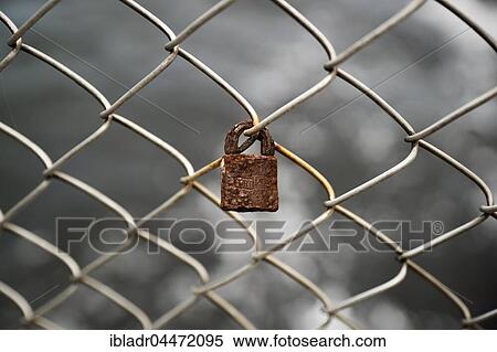 Rusty lock on chain-link fence, symbol, rusting, ephemeral love View Large Photo Image Stock Photography - Rusty lock on chain-link fence, symbol, rusting, ephemeral love. Fotosearch