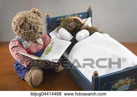 Sick Teddy Bear with bandaged paws and head, holding thermometer, in an original Pumuckl crib, Big Teddy Bear with glasses and bowtie reads from book View Large Photo Image Stock Photo - Sick Teddy Bear with bandaged paws and head, holding thermometer, in an original Pumuckl crib, Big Teddy Bear with glasses and bowtie reads from book. Fotosearch