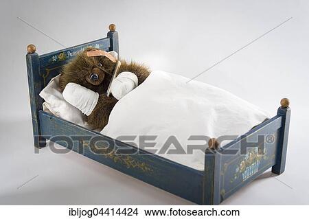 Sick Teddy Bear with head and paws bandaged, holding thermometer, in an original Pumuckl crib View Large Photo Image Picture - Sick Teddy Bear with head and paws bandaged, holding thermometer, in an original Pumuckl crib. Fotosearch