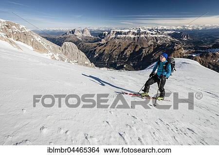 Picture - Ski mountaineer in ascent to Punta Rocca, behind Sellastock, Langkofel and Plattkofel, snowy Alps, Fassa Valley, Dolomites, South Tyrol, Italy, Europe. Fotosearch