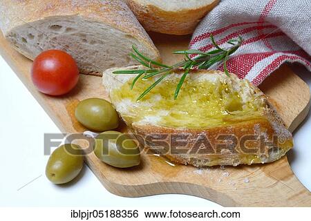 Stock Photograph - Slice of bread with olive oil, Mediterranean, Mediterranean diet, rosemary. Fotosearch