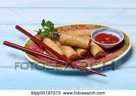 Stock Image - Spring roll and bowl with sauce. Fotosearch