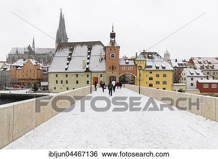 Stock Photograph - Stone bridge with gate, Salzstadel and Cathedral of St. Peter, snowfall, Regensburg, Upper Palatinate, Germany, Europe. Fotosearch