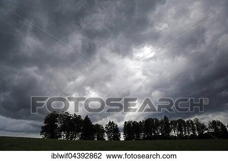 Storm clouds over field and row of trees in Beuerberg, Upper Bavaria, Germany, Europe View Large Photo Image Stock Image - Storm clouds over field and row of trees in Beuerberg, Upper Bavaria, Germany, Europe. Fotosearch