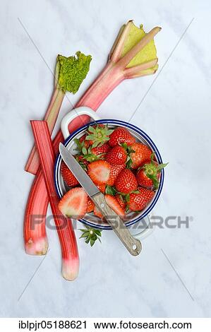 Stock Image - Strawberries in skin and rhubarb, rhubarb stalks, rheum rhabarbarum, rhubarb stalks. Fotosearch