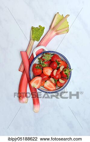 Stock Image - Strawberries in skin and rhubarb, rhubarb stalks, rheum rhabarbarum, rhubarb stalks. Fotosearch