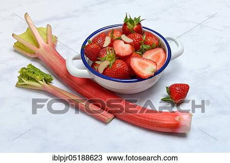 Stock Image - Strawberries in skin and rhubarb, rhubarb stalks, rheum rhabarbarum, rhubarb stalks. Fotosearch