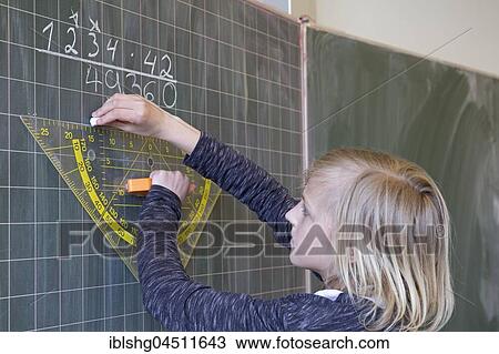 Stock Image - Student calculating on the blackboard, mathematics lessons, primary school, Lower Saxony, Germany, Europe. Fotosearch