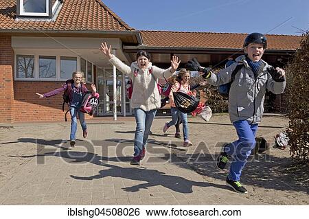 Stock Photograph - Students after school, start of vacacions, running out of school, primary school, Lower Saxony, Germany, Europe. Fotosearch