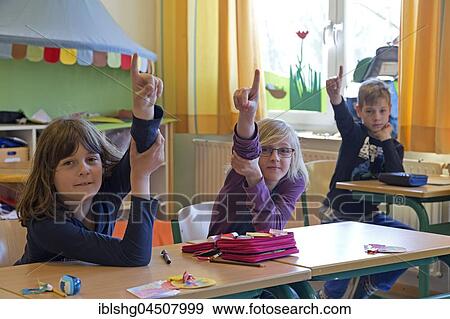Students in elementary school with raised hands in classroom, Lower Saxony, Germany, Europe View Large Photo Image Stock Photo - Students in elementary school with raised hands in classroom, Lower Saxony, Germany, Europe. Fotosearch