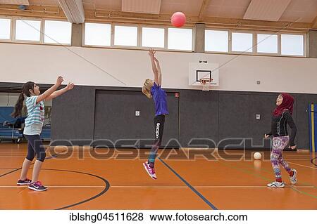 Stock Photo - Students playing ball in the gym, physical education, primary school, Lower Saxony, Germany, Europe. Fotosearch
