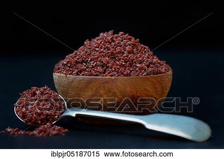 Stock Photography - Sumac powder in wooden bowl and spoon, Rhus coriaria. Fotosearch