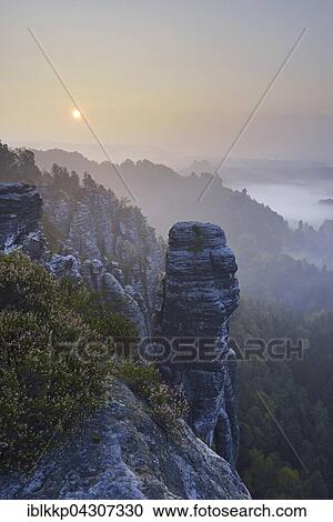 Sunrise with fog, Rathener Kessel with Hoellenhund Rocks, Saxon Switzerland National Park, Elbe Sandstone Mountains, Rathen, Saxony, Germany, Europe View Large Photo Image Stock Image - Sunrise with fog, Rathener Kessel with Hoellenhund Rocks, Saxon Switzerland National Park, Elbe Sandstone Mountains, Rathen, Saxony, Germany, Europe. Fotosearch