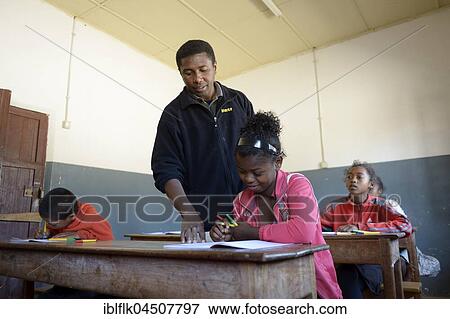 Teacher helping a female student, 15 years, Primary School, Fianarantsoa, Madagascar, Africa View Large Photo Image Stock Photo - Teacher helping a female student, 15 years, Primary School, Fianarantsoa, Madagascar, Africa. Fotosearch