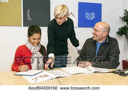 Stock Image - Teacher shows student something in a book, German course at a language school, Düsseldorf, North Rhine-Westphalia, Germany, Europe. Fotosearch