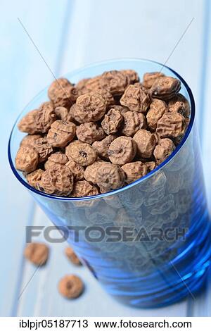 Stock Image - Tigernuts in glass, Cyperus esculentus. Fotosearch