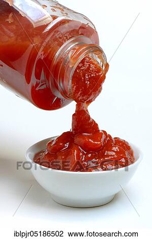 Tomato ketchup flows from bottle into bowl View Large Photo Image Stock Image - Tomato ketchup flows from bottle into bowl. Fotosearch