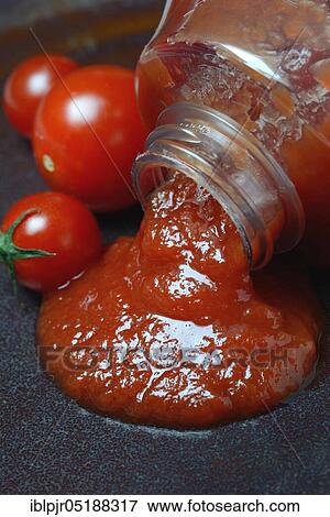 Stock Photo - Tomato ketchup flows from bottle. Fotosearch