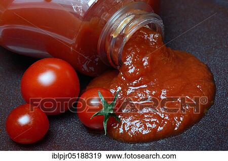 Stock Photo - Tomato ketchup flows from bottle. Fotosearch