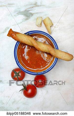 Stock Photograph - Tomato soup in cup with breadstick and tomatoes. Fotosearch